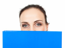 business woman's eyes peeking over a blue binder 