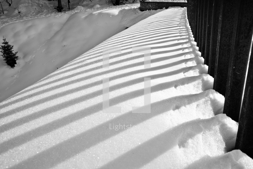 snow against fence rails