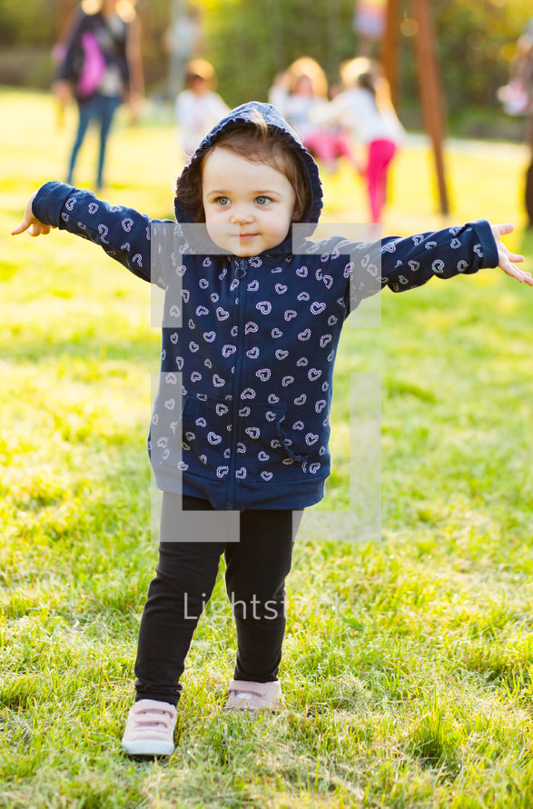 toddler girl playing outdoors at a park 