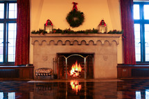 Burning fireplace adorned with Christmas decorations.