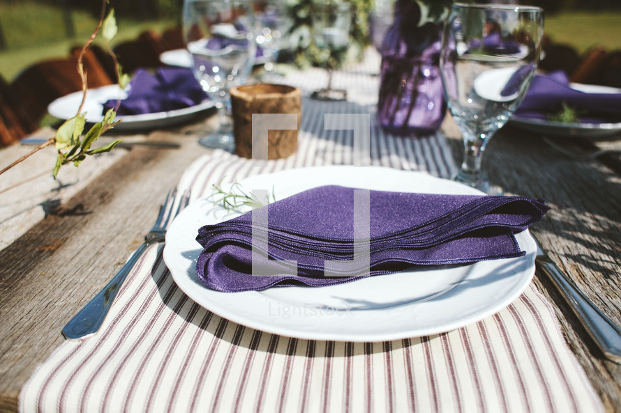 purple napkins on plates for a dinner party 
