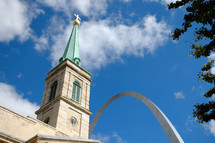 Cathedral with a cross on the steeple near the Gateway Arch.