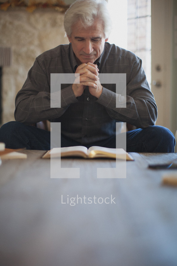 man reading a Bible and praying