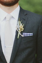 Bearded man with corsage on his jacket lapel.
