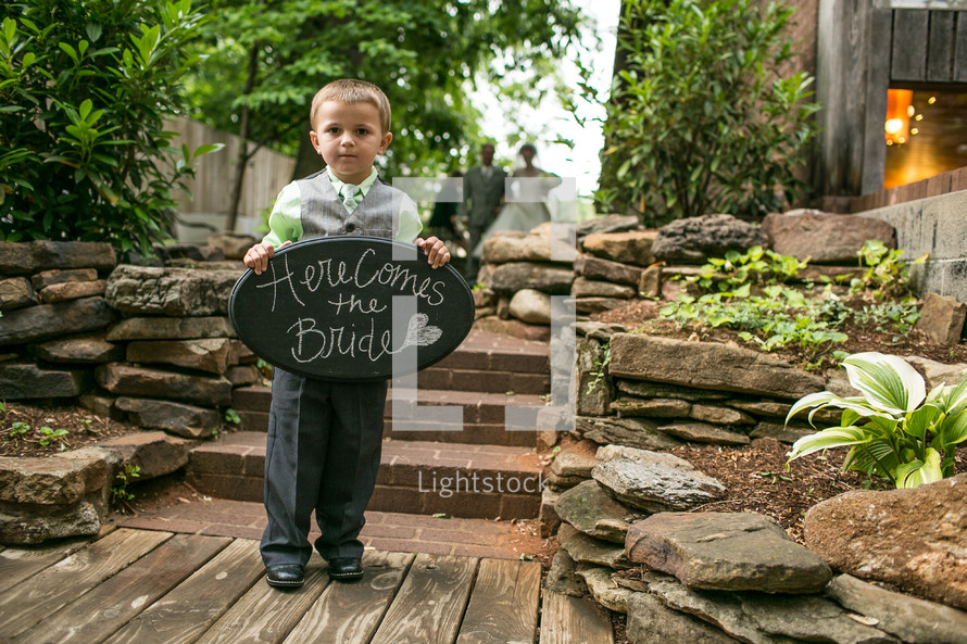 ring bearer holding a sign 