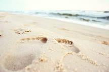 footprints in sand on a beach 
