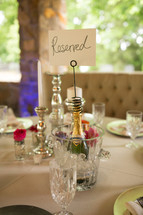 Reserved sign on a champagne bottle at a wedding reception table 
