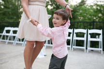 a young boy dancing with a woman at a wedding reception 