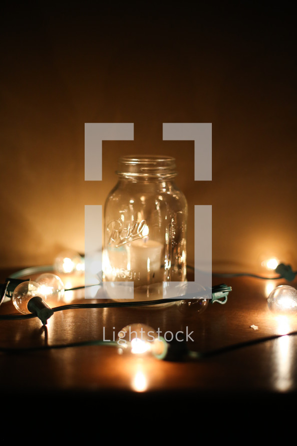 votive candle in a mason jar and a string of lights