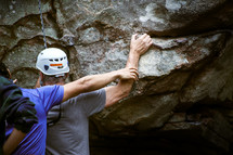 man rock climbing with an instructor 
