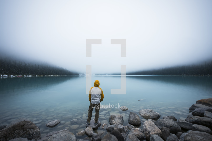 a man standing on the shore of Lake Louise 