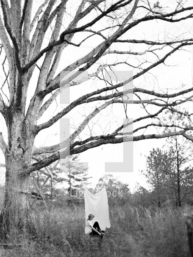 woman sitting under a tree 