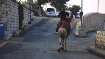 Israel Man riding camel down the street 