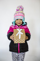 a girl holding a wrapped Christmas gift 