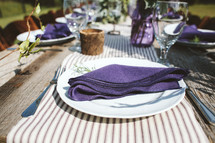 purple napkins on plates for a dinner party 