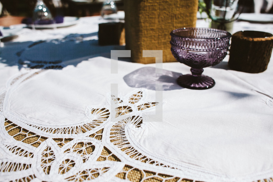 lace table cloth and set table for an outdoor wedding 