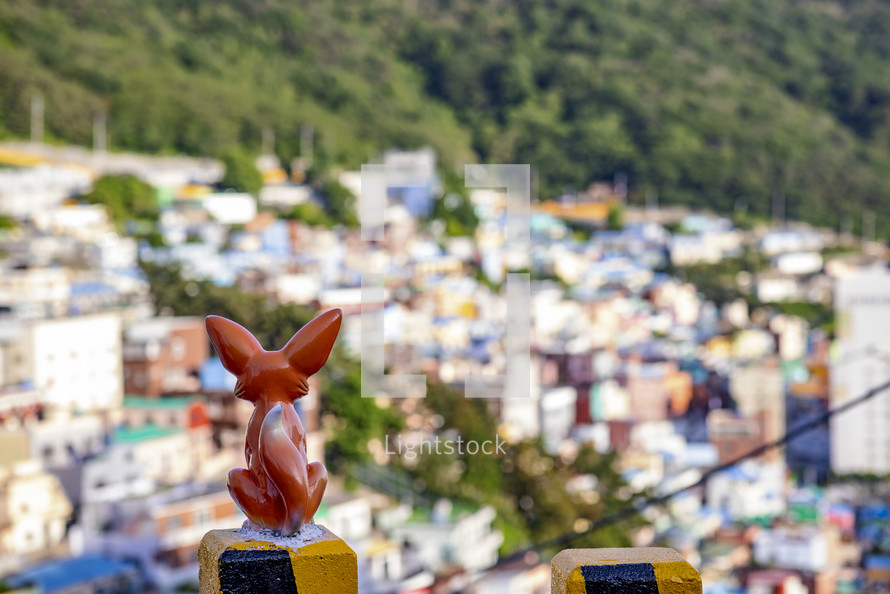 a concrete fox overlooking old Busan, Korea