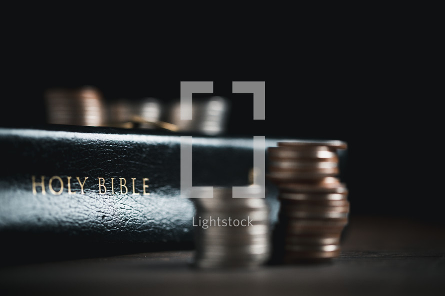 Coins next to a Bible