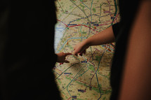 a couple pointing a map 