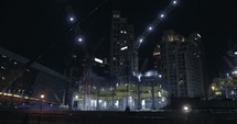 Skyscraper, building in Dubai under construction in downtown city in the United Arab Emirates. Construction cranes and workers at night.