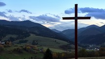 Timelapse of wooden cross on a rural landscape at dusk.
