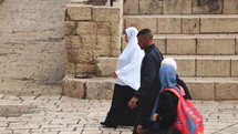 Muslim Women walking through ancient city wall Middle East culture authentic women diversity rights