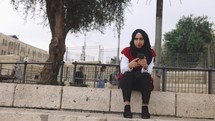 Muslim Woman Wearing Hijab using a cell phone smartphone Culture Female authentic Middle East Israel
