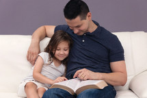 Man Reading Holy Bible with his daughter 