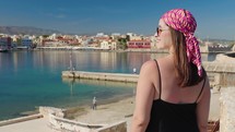 Woman tourist enjoying Bay Of Chania At Sunny Summer Day In Crete, Greece. 
