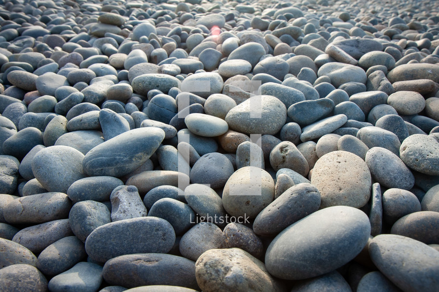 many smooth grey and tan rocks stones pebbles on the shore in lima peru horizontal