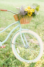 A basket of flowers on a bicycle.