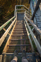 Shoes of explorer going down wood and metal watchtower steps in Bickle Knob West Virginia
