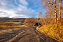 Path leading to covered footbridge during autumn panorama