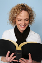 woman smiling reading the Bible 