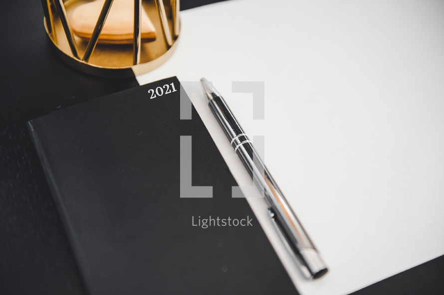 planner for 2021, white paper, and pen on a desk 