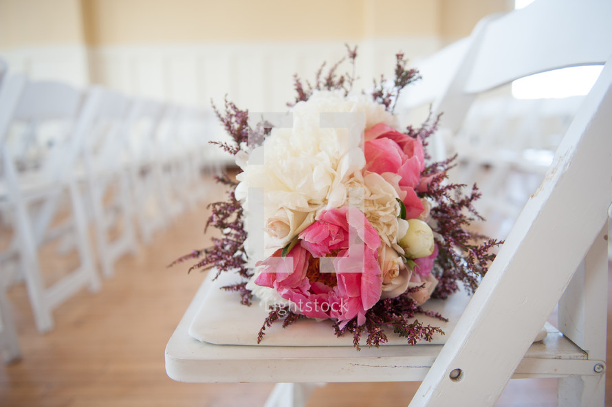 bridal bouquet on a white folding chair