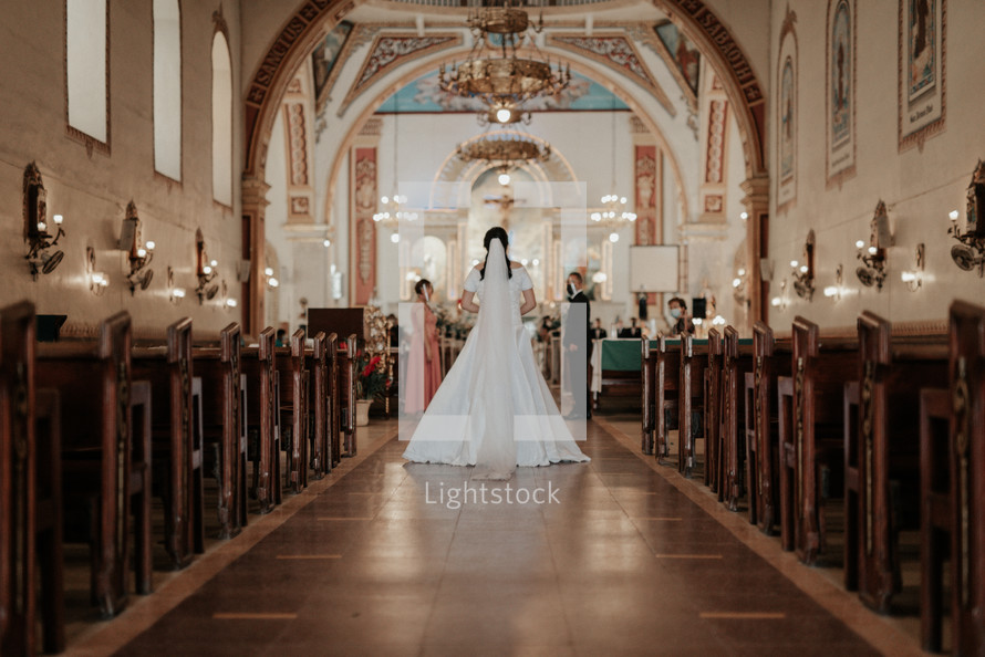a bride walking down a aisle in a church wedding 