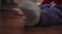 feet of a toddler playing in curtains 