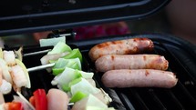 Sausages Cooking with Flames on a Barbecue Grill
