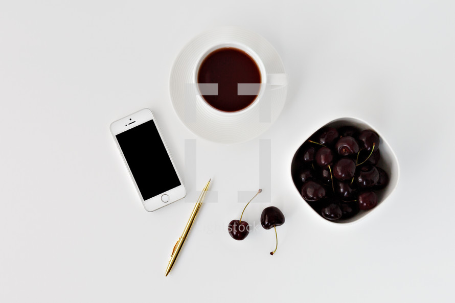iPhone, pen, cherries, and coffee cup 