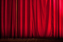Closed red stage curtain of a theater.