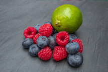 Blueberries, Raspberries and Lime on a Grey Slate