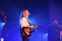 a woman singing during a worship service 
