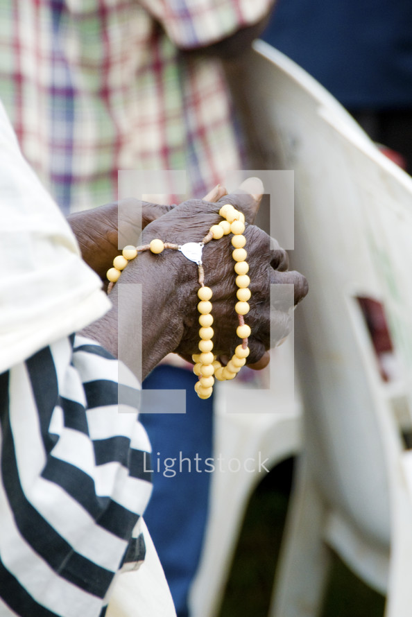 A black woman holds prayer beads