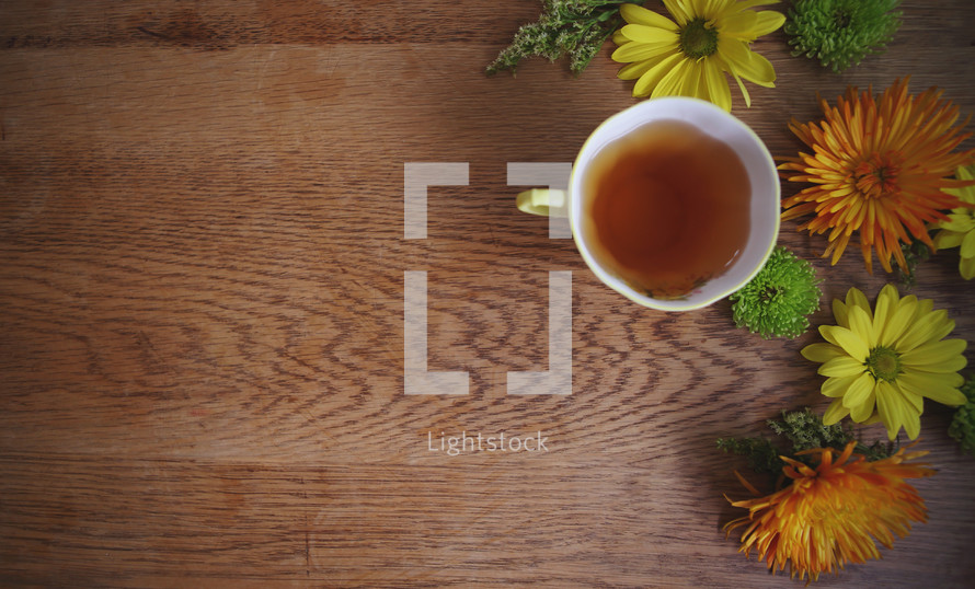 a cup of tea on table with bright flowers