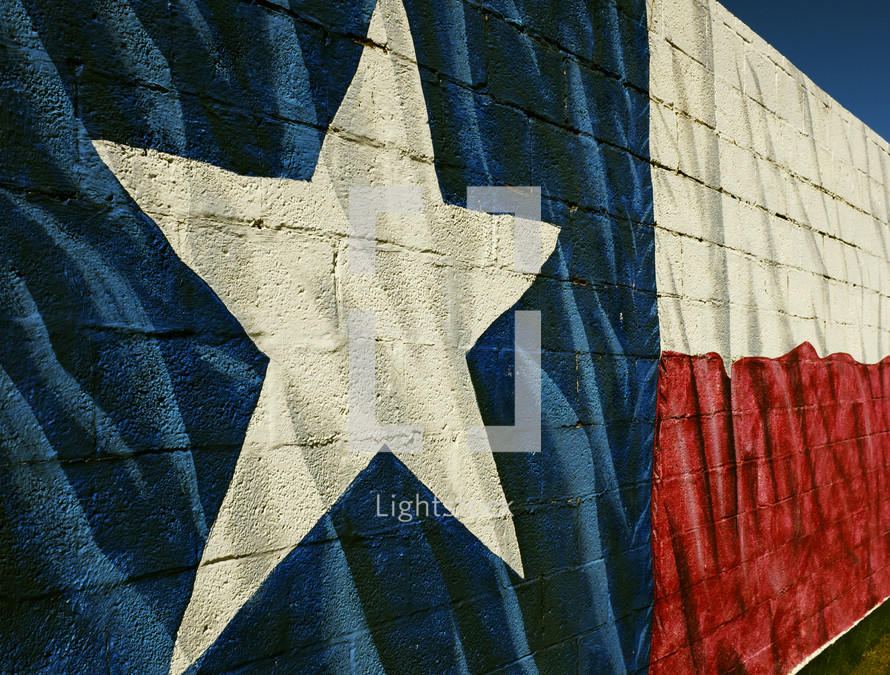 Texas flag mural painted on a brick wall.