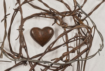 Stone heart surrounded by barbed wire.