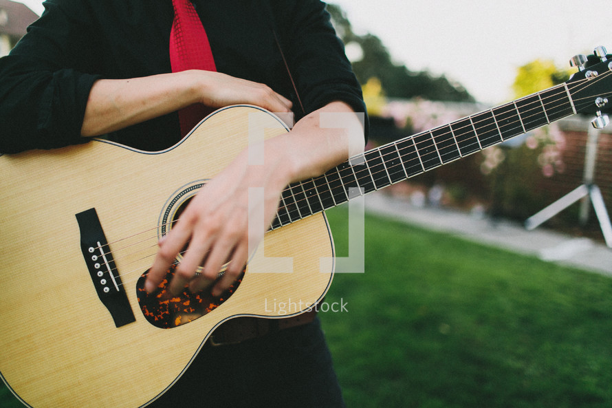 Holding a guitar.