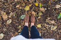 Standing in the dirt with fall leaves.