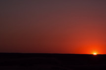 sunset behind desert sand dunes 
